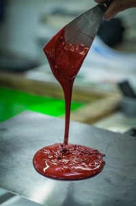 Image of red ink dripping from a spatula